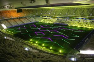 Europe Évènement - Animations projections - Photo of a stadium with splashes of green and purple geometric shapes on it